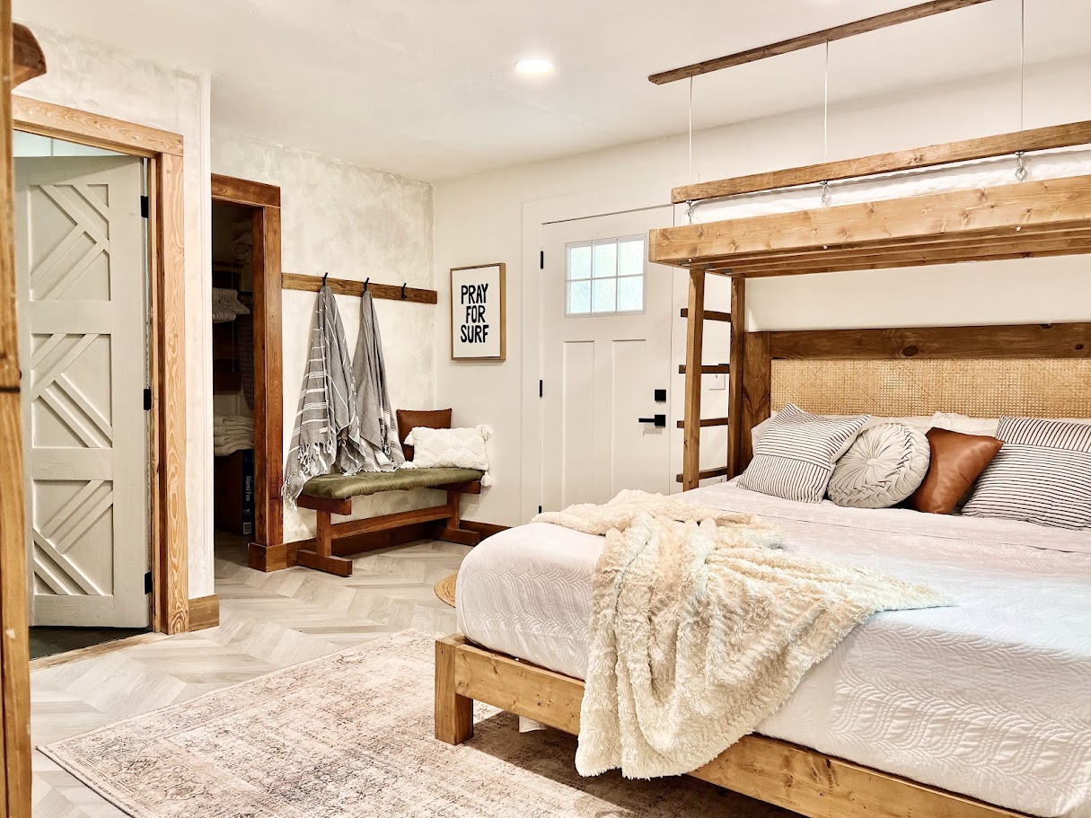 Bedroom after renovation by Madeira Studios — custom bed frame and door
