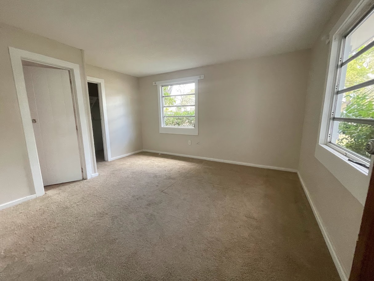 Bedroom before renovation — empty room with carpet
