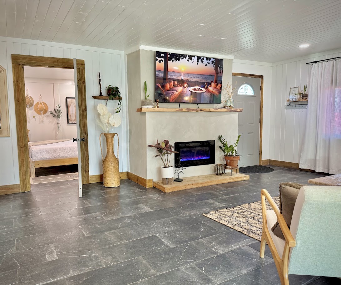 Living room after renovation by Madeira Studios — custom fireplace and door