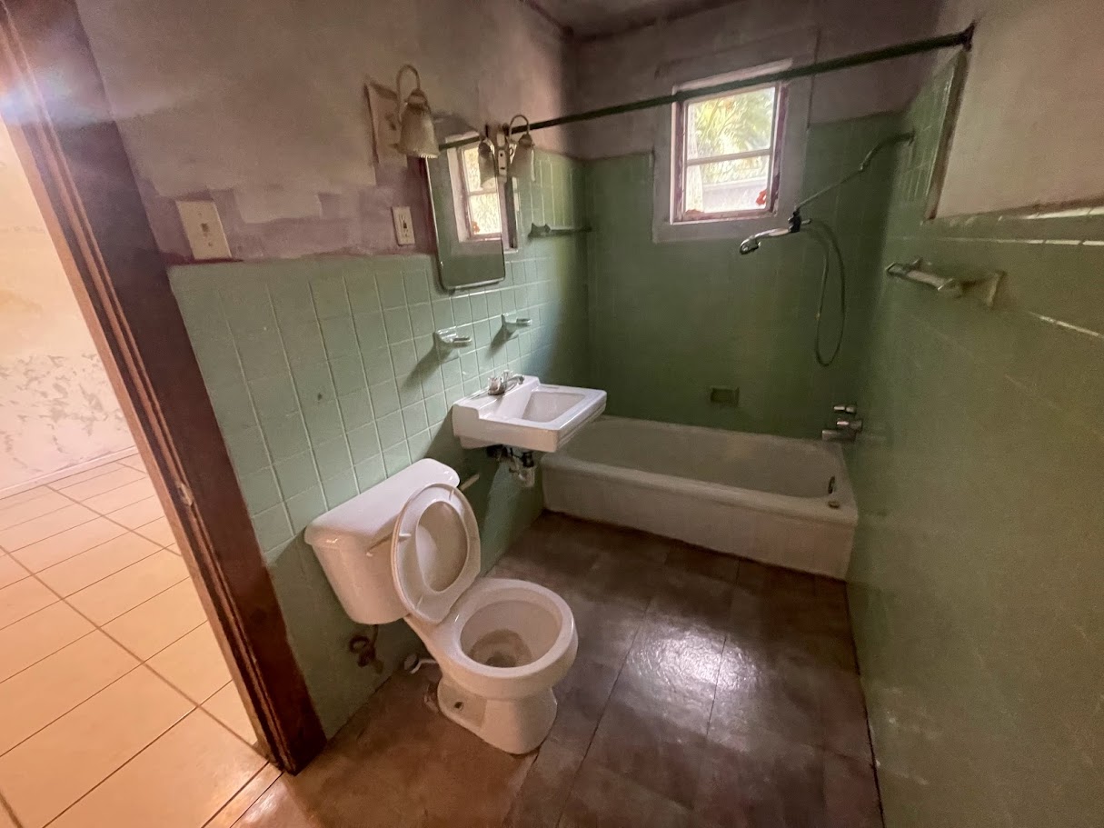 Bathroom before renovation — original green tile