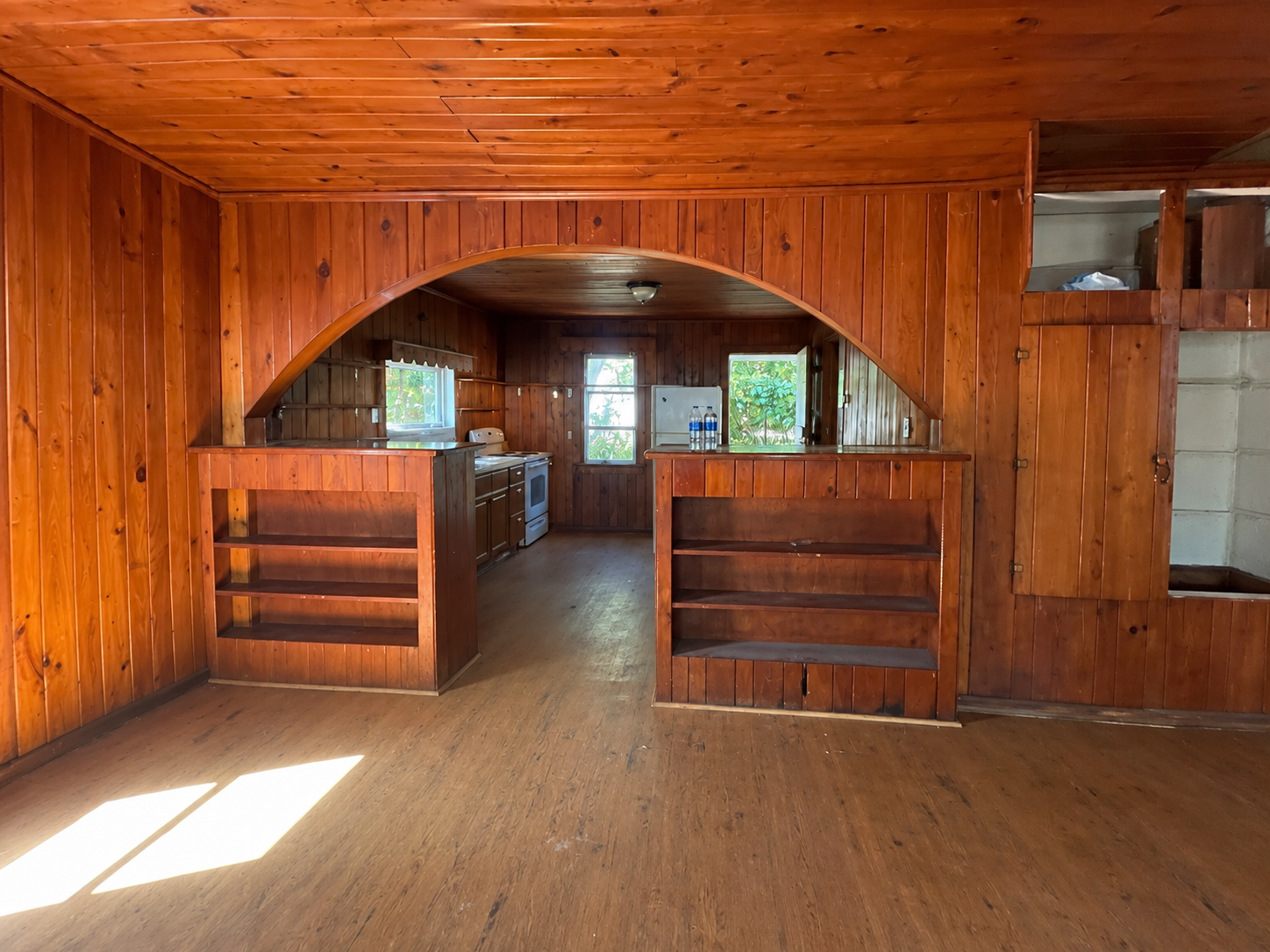 Kitchen before renovation — original wood archway and paneling