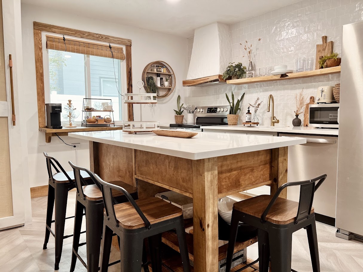Kitchen after renovation by Madeira Studios — custom island and open shelving