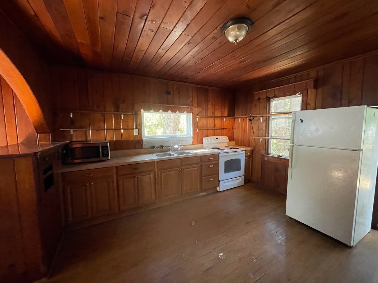 Kitchen before renovation — dark wood paneling